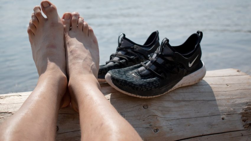 persons feet on brown wooden floor